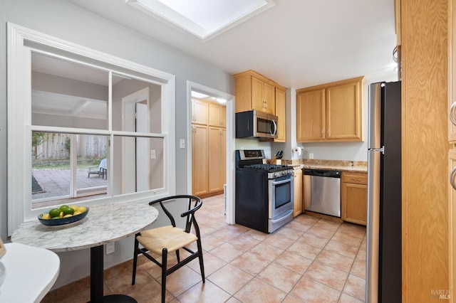 kitchen featuring light tile patterned flooring, light brown cabinetry, and stainless steel appliances