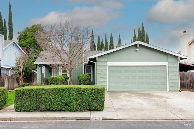 ranch-style house featuring a garage, brick siding, fence, and driveway