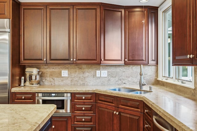 kitchen with appliances with stainless steel finishes, sink, and decorative backsplash