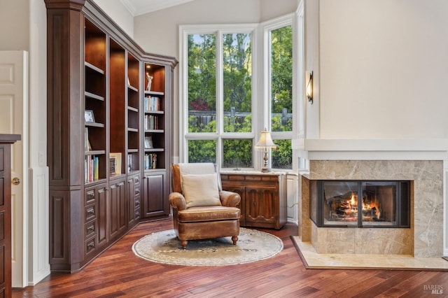 sitting room with a fireplace, plenty of natural light, dark hardwood / wood-style floors, and ornamental molding