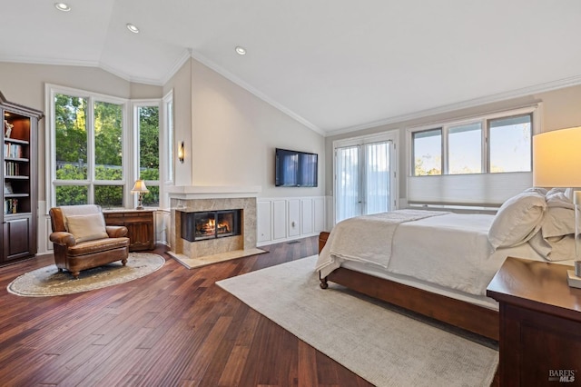 bedroom featuring lofted ceiling, access to exterior, ornamental molding, hardwood / wood-style flooring, and a fireplace