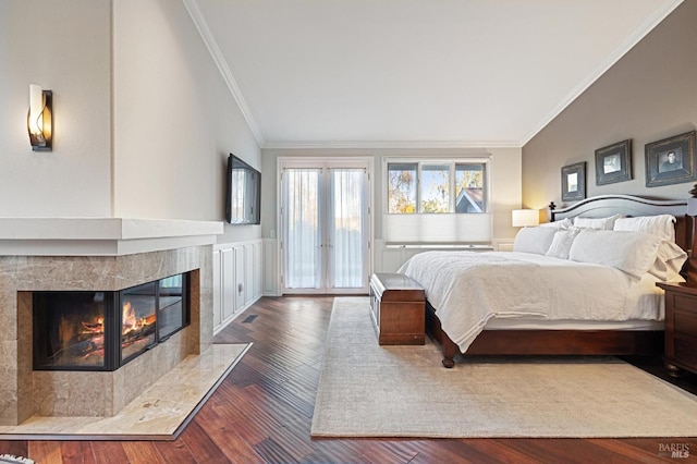 bedroom with a tiled fireplace, crown molding, dark hardwood / wood-style floors, and access to outside