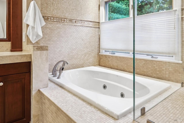 bathroom with a relaxing tiled tub and vanity