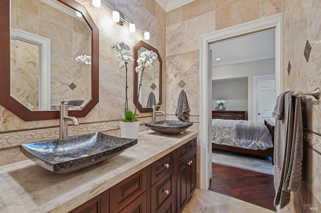 bathroom featuring ornamental molding, vanity, and tile walls