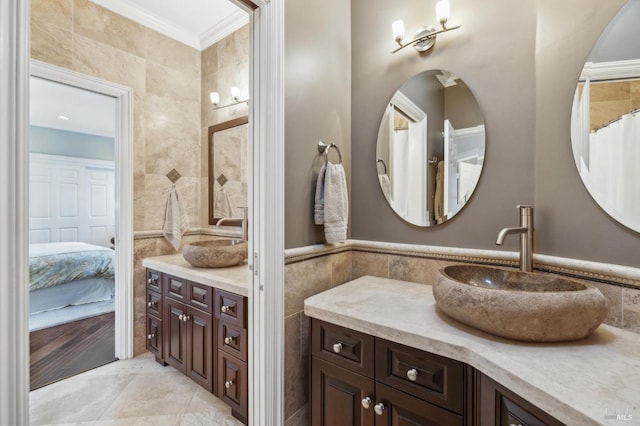 bathroom featuring ornamental molding, vanity, tile patterned flooring, and tile walls