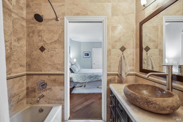 bathroom with vanity, shower / bath combination, and tile walls