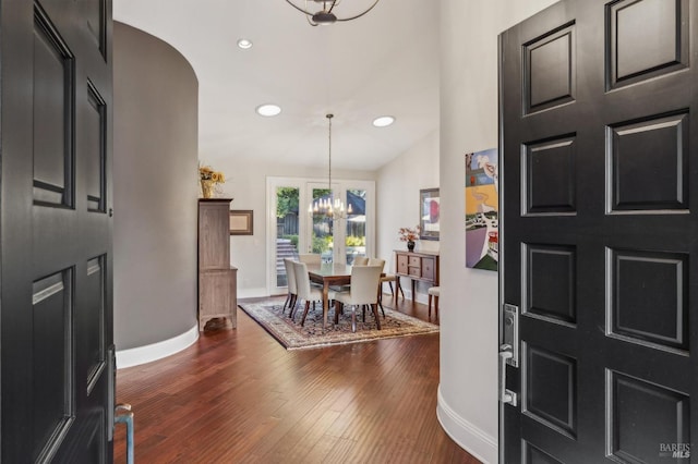 entrance foyer with an inviting chandelier, dark hardwood / wood-style floors, and vaulted ceiling