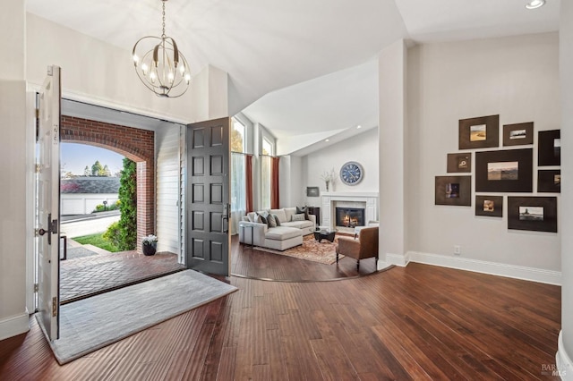 entrance foyer with high vaulted ceiling, dark hardwood / wood-style floors, and a chandelier