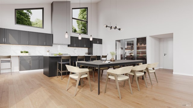 dining room with a high ceiling and light wood-type flooring