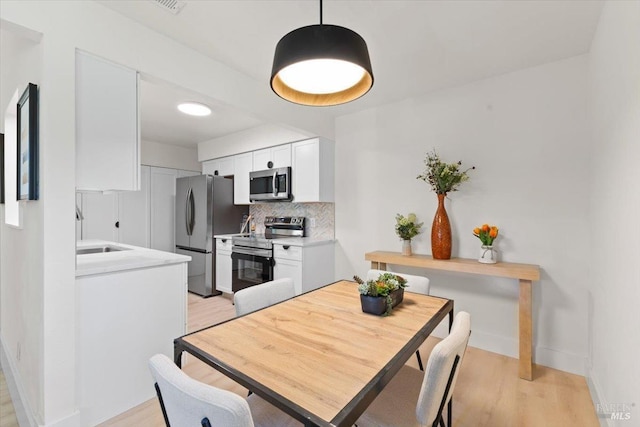 dining area with sink and light hardwood / wood-style floors