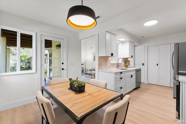 dining room featuring sink and light hardwood / wood-style floors