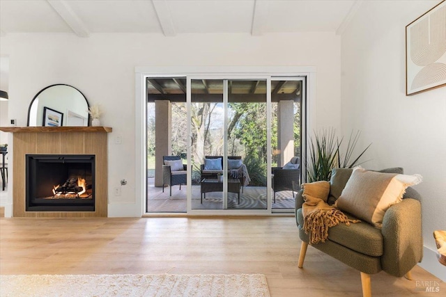 living area with beam ceiling and light hardwood / wood-style flooring