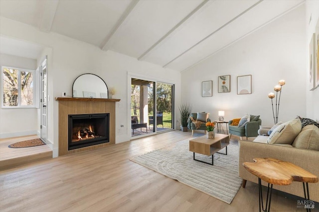 living room with beamed ceiling, high vaulted ceiling, and light hardwood / wood-style flooring