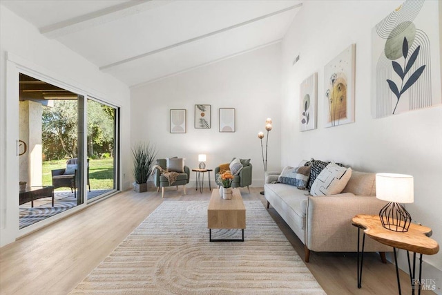 living room with lofted ceiling with beams and light hardwood / wood-style floors