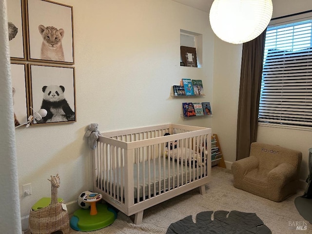 bedroom featuring light colored carpet and a crib