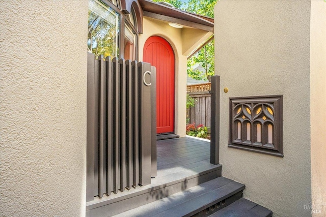 property entrance featuring fence and stucco siding