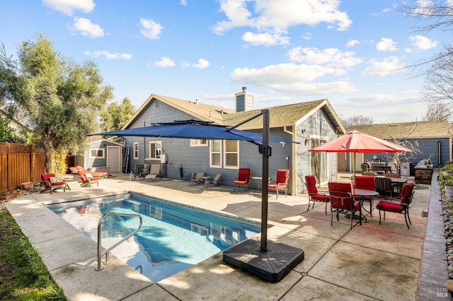 view of pool featuring a fenced in pool, a fenced backyard, a patio area, outdoor dining space, and an outbuilding