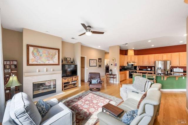 living area featuring visible vents, light wood-style flooring, recessed lighting, a fireplace, and ceiling fan