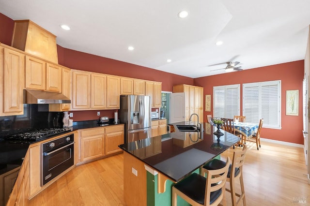 kitchen featuring wall oven, under cabinet range hood, black gas cooktop, stainless steel refrigerator with ice dispenser, and a sink