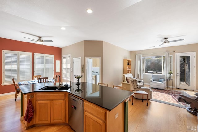 kitchen with a ceiling fan, a sink, stainless steel dishwasher, dark countertops, and open floor plan