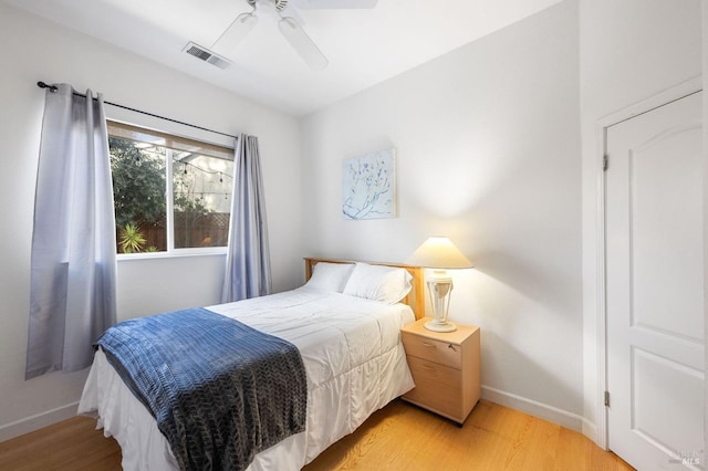 bedroom featuring visible vents, baseboards, light wood-style floors, and a ceiling fan