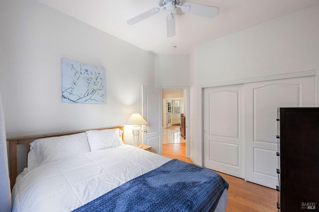 bedroom with light wood-style flooring, a ceiling fan, and a closet