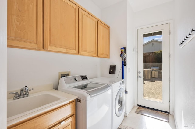 laundry area with separate washer and dryer, cabinet space, and a sink