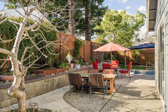 view of patio with outdoor dining space and a fenced backyard