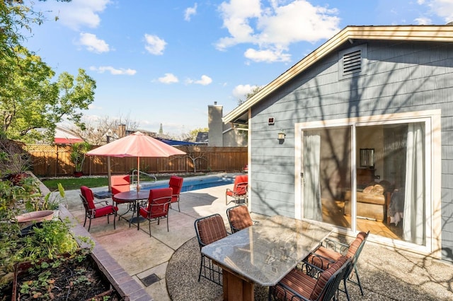 view of patio with outdoor dining space, a fenced backyard, and a fenced in pool