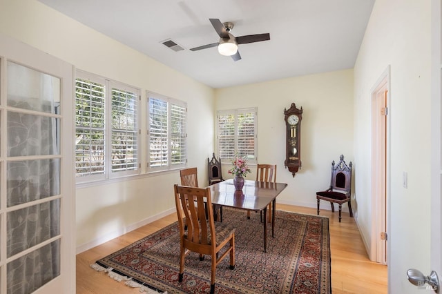 dining room featuring baseboards, visible vents, light wood finished floors, and ceiling fan