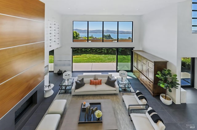 living room with a mountain view, a towering ceiling, and dark tile patterned flooring