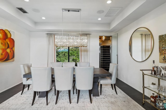 dining room featuring an inviting chandelier and a tray ceiling