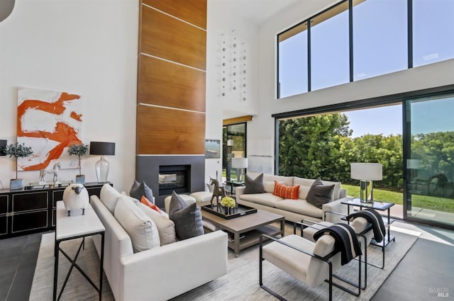 living room featuring tile patterned flooring, a multi sided fireplace, and a towering ceiling