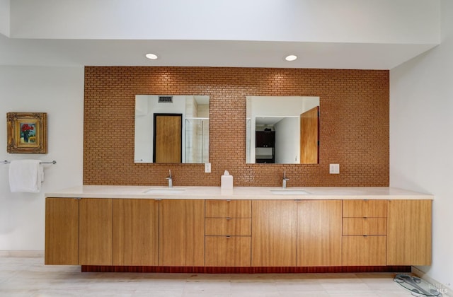 bathroom with walk in shower, vanity, and decorative backsplash