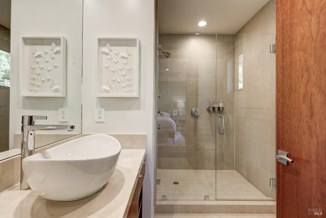 bathroom featuring vanity and a shower with shower door