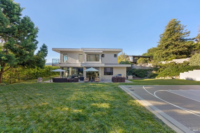 rear view of house featuring an outdoor hangout area, basketball court, and a lawn