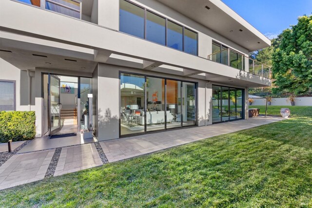 back of house featuring a patio area and a lawn