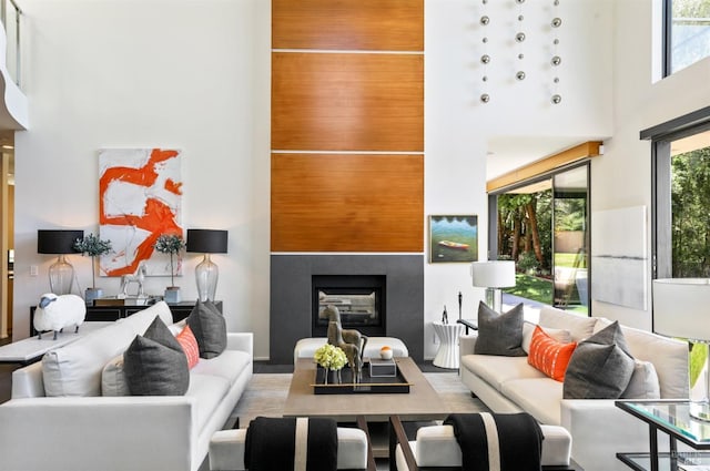 living area featuring a tiled fireplace and a high ceiling