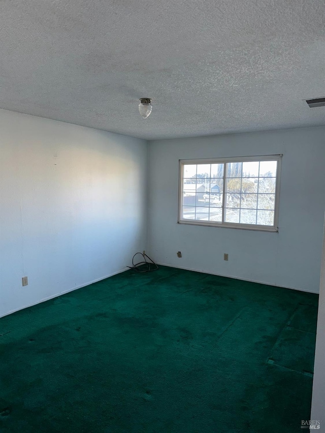 carpeted empty room with a textured ceiling