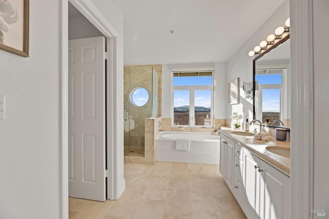 bathroom featuring plus walk in shower, a wealth of natural light, and vanity