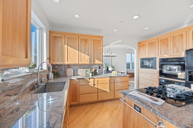 kitchen featuring stone counters, tasteful backsplash, sink, and black appliances