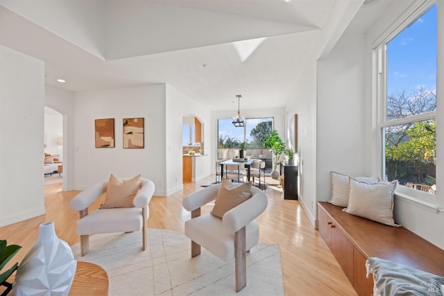 living room with an inviting chandelier and light wood-type flooring