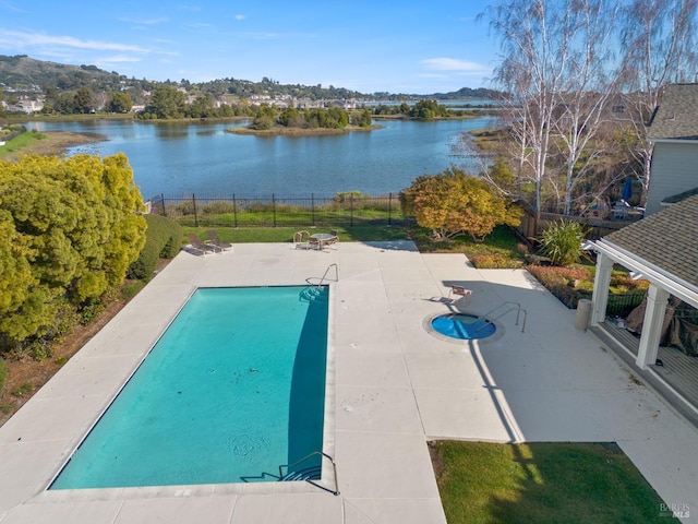 view of swimming pool featuring a water view and a patio area