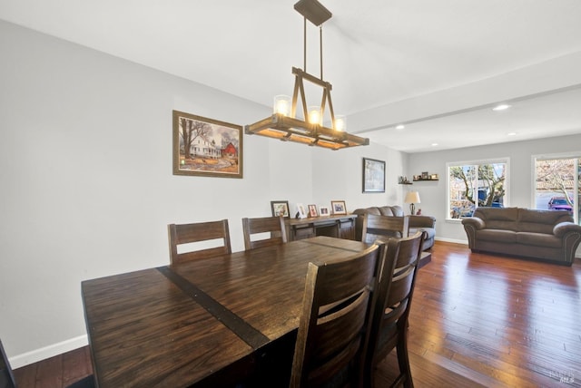 dining space with dark hardwood / wood-style floors and a notable chandelier