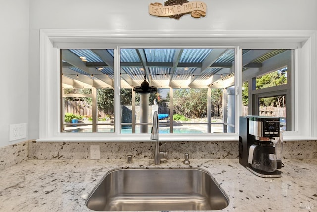 kitchen featuring sink and light stone countertops