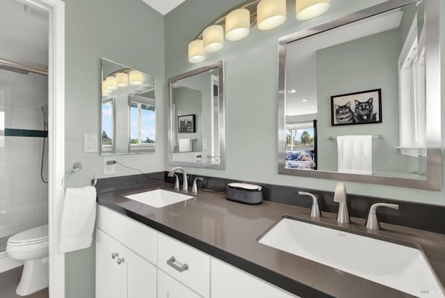 bathroom featuring vanity, toilet, and tiled shower