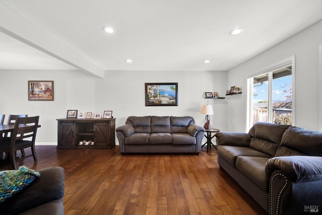 living room featuring dark wood-type flooring and beamed ceiling