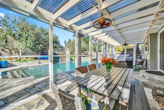 unfurnished sunroom featuring a patio and ceiling fan