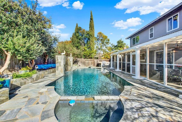 view of swimming pool featuring a patio area and a sunroom