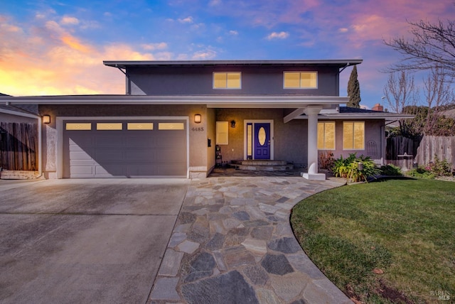 view of front of house featuring a garage and a lawn